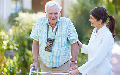 nursing homes near morrisville ny long term care image of elderly man with walker smiling while being assisted by female nurse on a sunny day outside